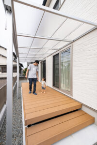 日差しと雨を遮る屋根を設置したウッドデッキ。半透明で暗くならず、雨の日も子どもが遊べて便利です。