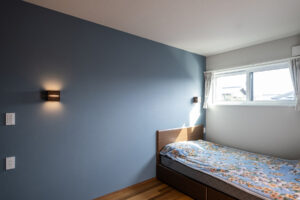 落ち着いたブルーのアクセントクロスが目を引く主寝室