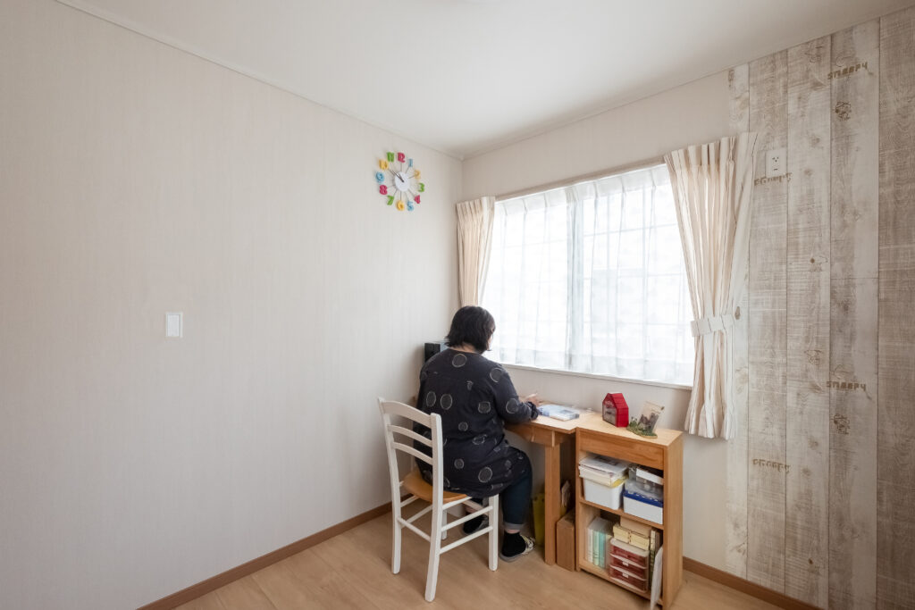 木目調アクセントクロスと作業机を設けた明るい洋室